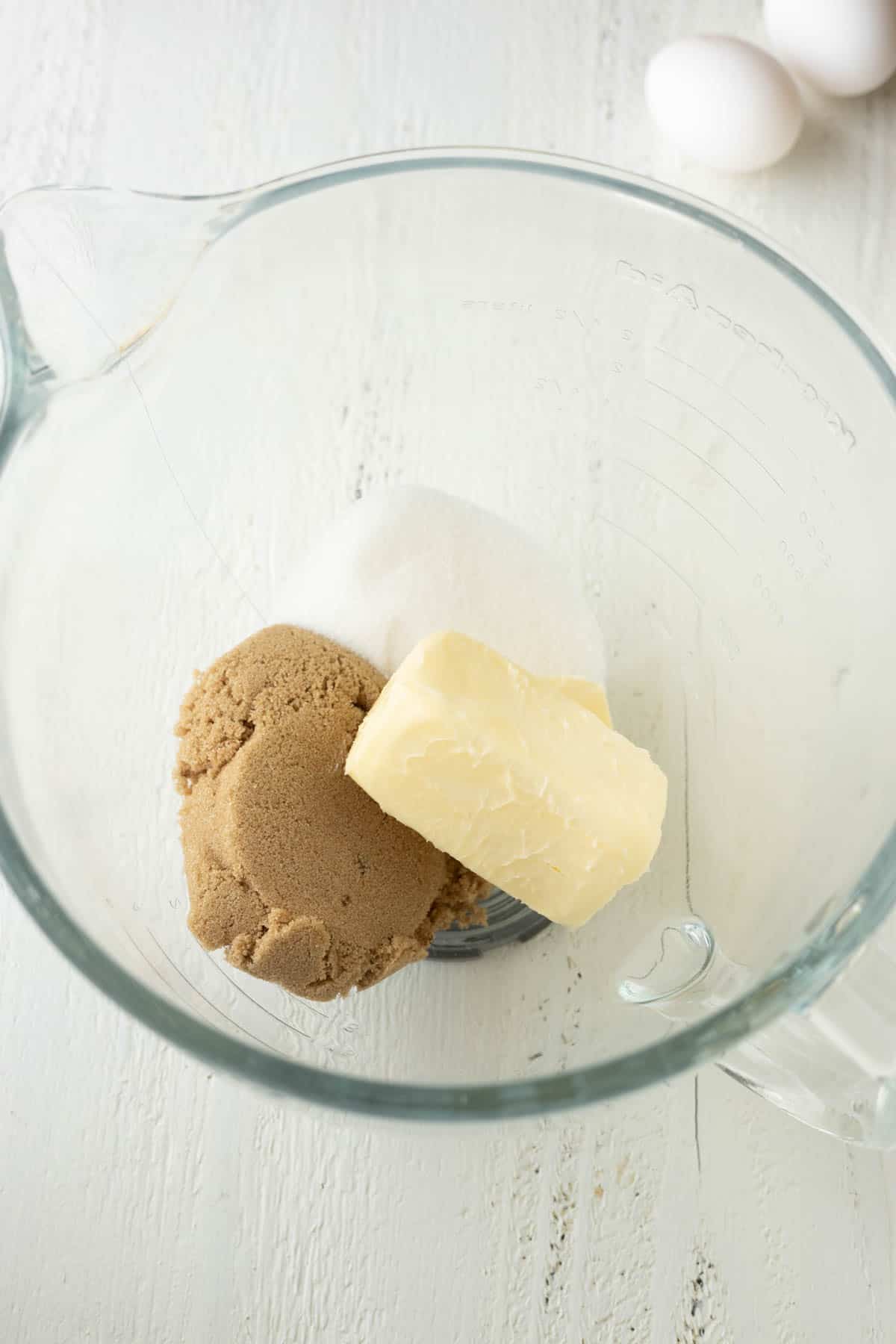 White sugar, brown sugar, and butter in a mixing bowl.