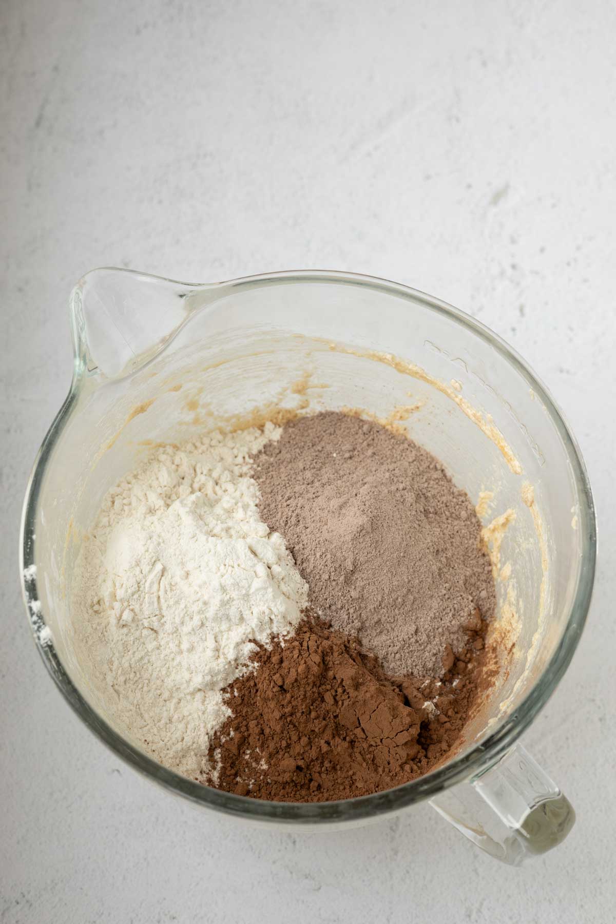 Flour, cocoa, and instant chocolate pudding mix in a mixing bowl with wet ingredients.