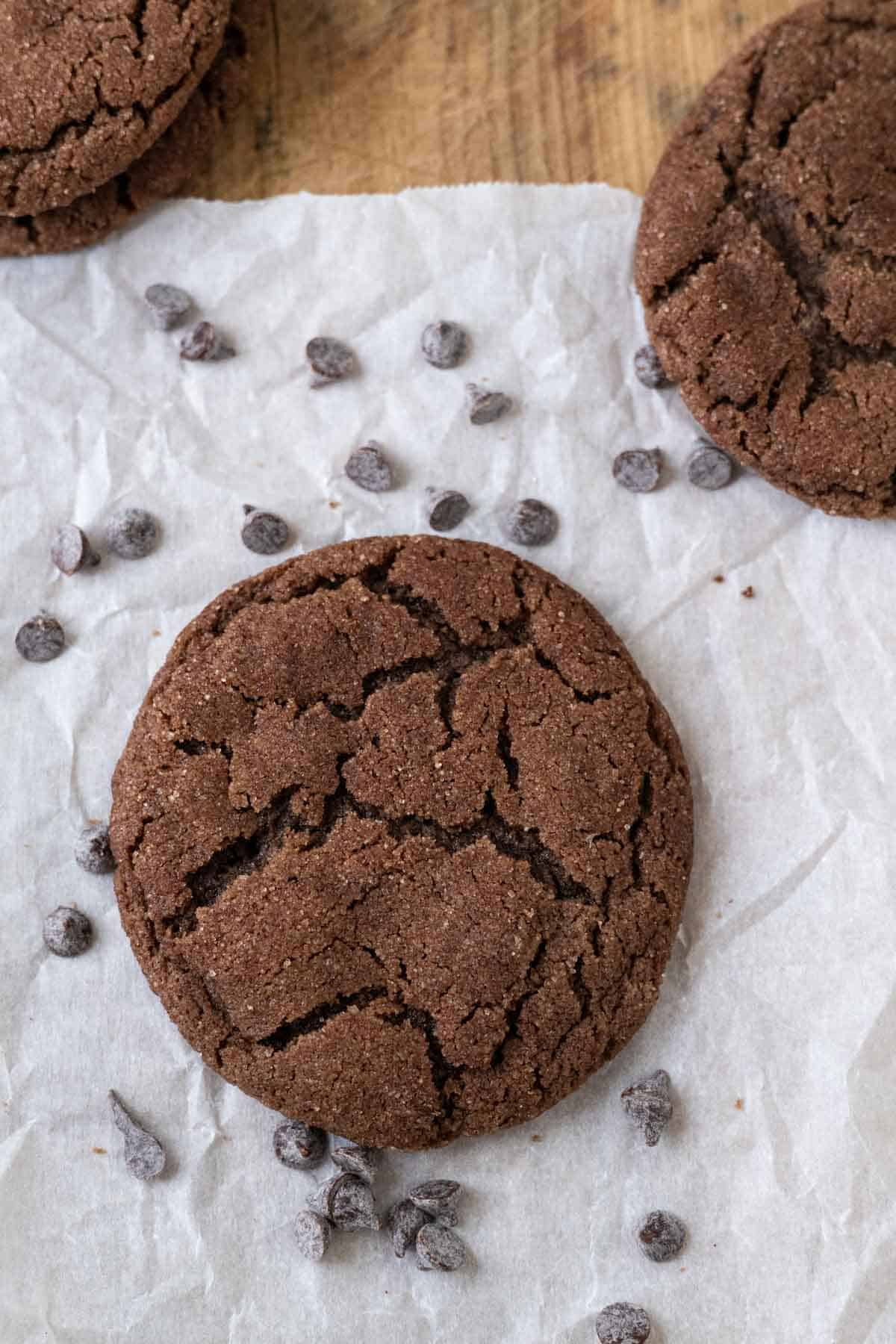 Chocolate Cinnamon Snickerdoodles on a white with chocolate chips scattered around.