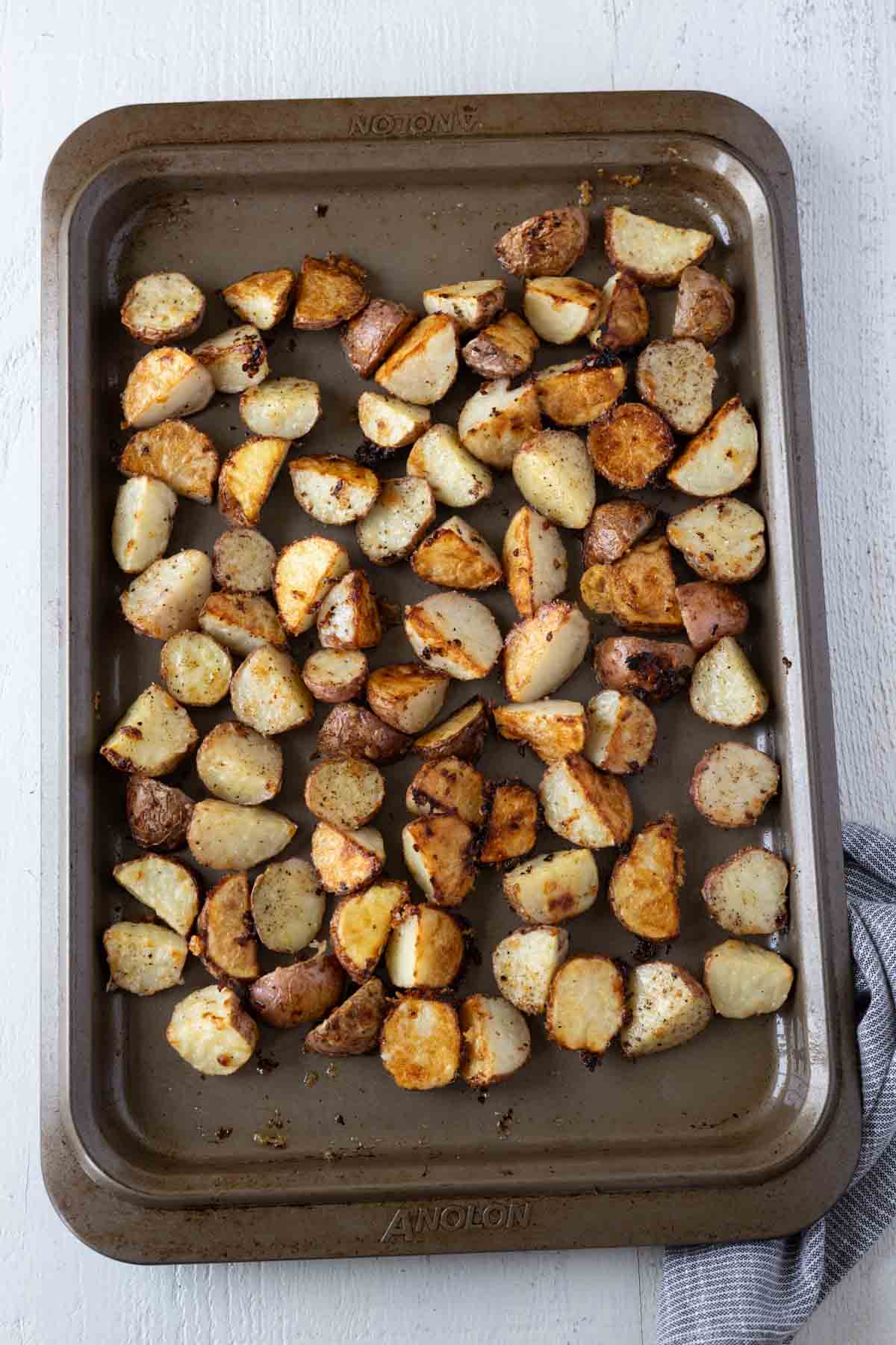 Golden brown roasted potatoes on cookie sheet.