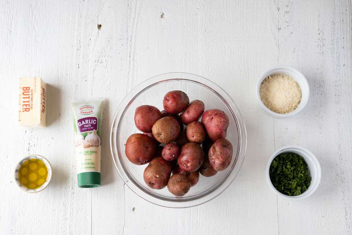 Ingredients needed to make red roasted potatoes with garlic, butter, seasonings, and herbs.